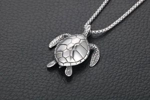 Close-up of titanium sea turtle pendant showing detailed shell texture on leather