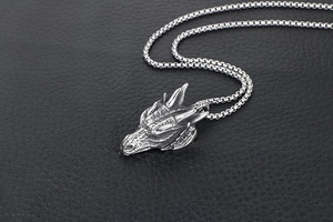 Détail du pendentif tête de dragon punk avec écailles argentées et chaîne carrée