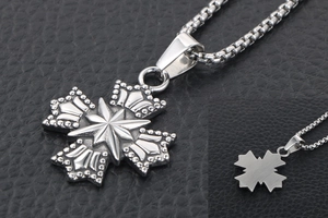Vue détaillée du pendentif croix rétro en acier inoxydable avec reliefs étoile et couronne