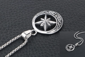 Macro detail of silver Union Jack pattern pendant with crescent moon on box chain