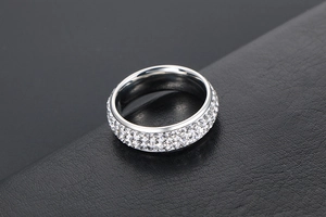 Gros plan d'une bague en titane argenté avec trois rangées de cristaux incrustés