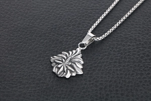 Macro d'un pendentif étoile rétro en argent avec détails de feuilles et chaîne box
