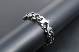 Détail macro du bracelet gourmette punk en acier titane argenté avec fermoir mousqueton