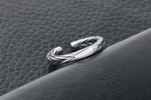 Detail of wheat-ear braided titanium steel ring with polished silver open band
