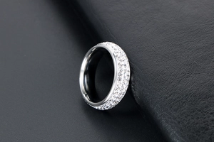 Vue macro d'une bague en acier titane argenté sertie de trois rangées de cristaux brillants