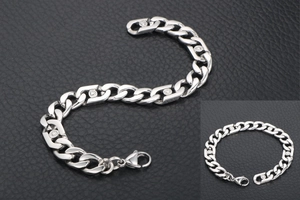 Détail d'un bracelet gourmette argenté avec fermoir mousqueton et zircon rond