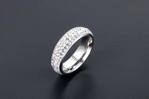 Détail de la bague en argent sertie de cristaux pavés sur un fond gris texturé