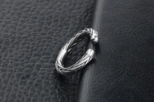 Macro detail of silver wheat ear pattern titanium steel open ring on black leather