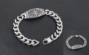 Macro view of men's titanium steel curb chain bracelet with engraved star and scroll details