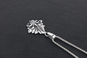 Vue détaillée du pendentif vintage argenté avec motif d'étoile sur texture en cuir noir
