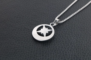 Macro detail of silver celestial star pendant on box chain over black leather background