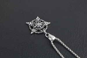 Close-up of vintage punk star pendant necklace with mystic symbols on black leather