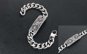 Détail d'un bracelet gourmette vintage en acier avec une plaque rectangulaire gravée d'étoiles