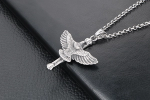 Vue macro d'un pendentif aigle argenté avec ailes détaillées sur cuir noir texturé
