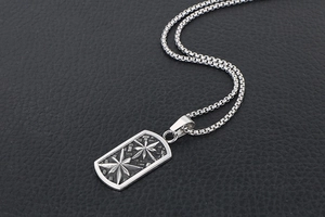 Close-up of vintage stainless steel dog tag necklace with embossed star pattern