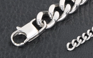 Détail macro du bracelet à mailles cubaines en acier poli avec fermoir mousqueton robuste