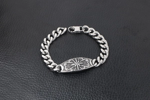 Macro view of a punk-style stainless steel Cuban link bracelet with a star pattern plaque