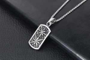 Close-up of vintage steel dog tag pendant with embossed stars and box chain texture