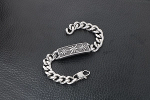 Detailed macro view of a silver titanium steel chain bracelet with engraved star plaque