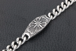 Macro detail of punk octagram star steel bracelet with vintage scroll texture on black leather