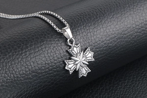 Détail du pendentif croix étoile flocon de neige en argent sur un fond de cuir noir élégant