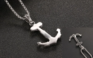 Macro detail of a punk style silver anchor pendant with intricate rope texture and box chain