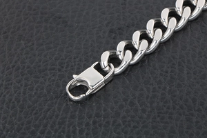 Polished titanium steel Cuban link bracelet with a secure lobster clasp on black leather