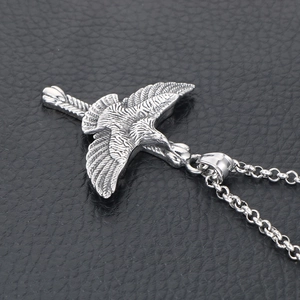 Pendentif aigle vintage en acier titane avec texture de plumes sur fond de cuir noir profond