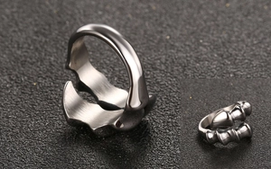 Macro detail of men's vintage claw-style open ring with mechanical ridges and gunmetal finish