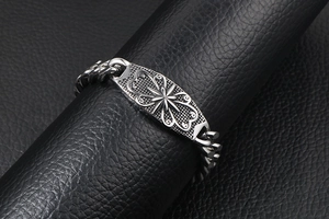 Macro shot of vintage silver steel Cuban bracelet with embossed star on black leather