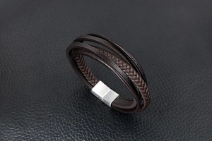 Detail eines dunkelbraunen mehrlagigen Lederarmbands mit gebürstetem silbernem Magnetverschluss