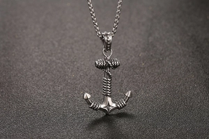 Detail of vintage anchor pendant with rope textures and square link chain