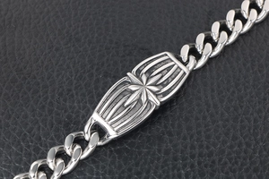 Macro shot of stainless steel curb chain bracelet with engraved star on black leather