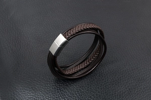 Detailaufnahme eines mehrlagigen Lederarmbands mit gebürstetem Magnetverschluss aus Silber