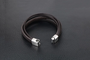 Nahaufnahme eines mehrlagigen braunen Lederarmbands mit gebürstetem Metall-Magnetverschluss