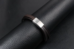 Detail eines mehrlagigen braunen Lederarmbands mit gebürstetem Metall-Magnetverschluss