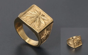 Macro detail of men's gold square signet ring with embossed leaf and stone texture
