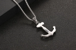 Detailed macro view of anchor pendant with cubic zirconia inlay on a silver box chain