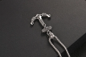 Macro shot of silver anchor pendant with rope detail on black textured background