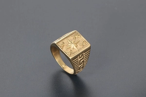 Macro shot of gold vintage signet ring with compass star and Greek meander patterns