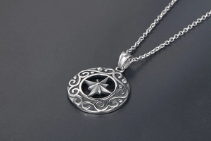 Dettaglio del ciondolo a stella vintage in argento con incisioni su catena a O