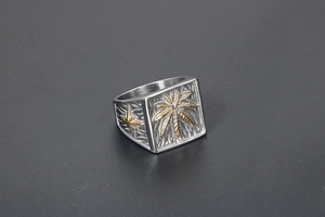 Macro shot of punk style signet ring featuring a golden leaf and star engravings