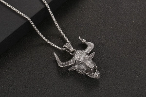 Macro shot of silver bull head pendant with detailed textures and vintage steel box chain