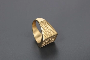 Detail of gold signet ring with engraved Greek key pattern and textured side texture