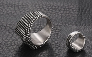 Détail macro de la bague punk en acier titane pour hommes avec texture rivetée et face polie