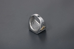 Macro view of retro punk leaf ring featuring golden floral relief on brushed steel