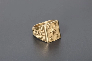 Macro shot of vintage gold signet ring featuring star engraving and Greek Key side details