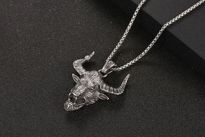 Detail of vintage bull head pendant with intricate carvings and box chain in silver