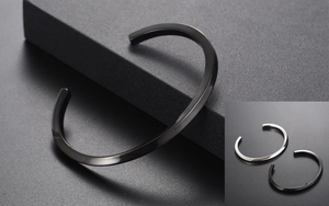 Close-up of minimalist black twisted open cuff bracelet with metallic glossy finish