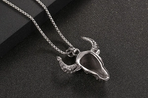 Macro shot of silver steer skull pendant showing the hollow back and polished steel texture